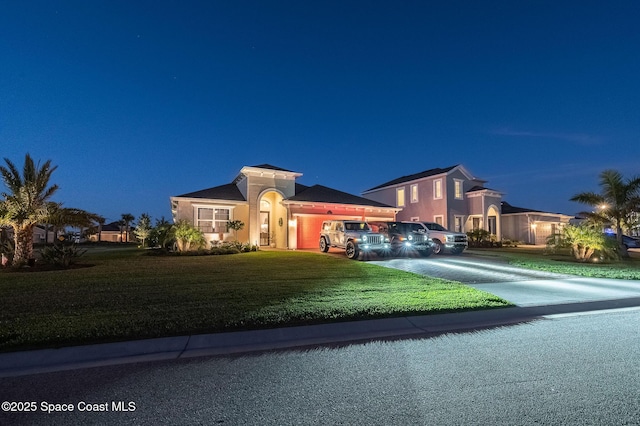 mediterranean / spanish home with a lawn, concrete driveway, and stucco siding
