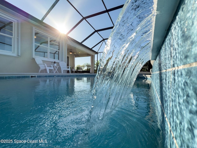 view of pool featuring a lanai, a pool, and ceiling fan