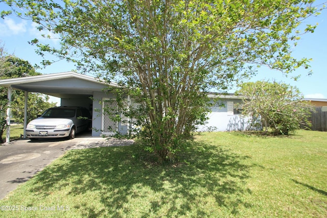 1798 Hudson Cir S, Melbourne, FL 32935 - view of front of home featuring a carport, fence, a front yard, and concrete driveway