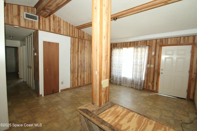 1798 Hudson Cir S, Melbourne, FL 32935 - foyer featuring visible vents, vaulted ceiling, wood walls, tile patterned floors, and ornate columns