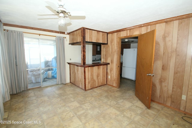 1798 Hudson Cir S, Melbourne, FL 32935 - kitchen featuring freestanding refrigerator, ceiling fan, and wooden walls
