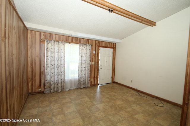 1798 Hudson Cir S, Melbourne, FL 32935 - unfurnished room featuring baseboards, wood walls, and beam ceiling