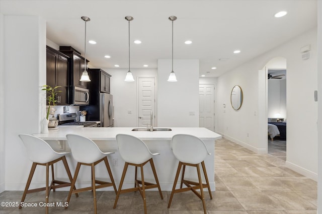 kitchen with a sink, light countertops, appliances with stainless steel finishes, and recessed lighting