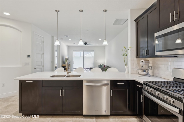 kitchen with stainless steel appliances, visible vents, light countertops, and a sink