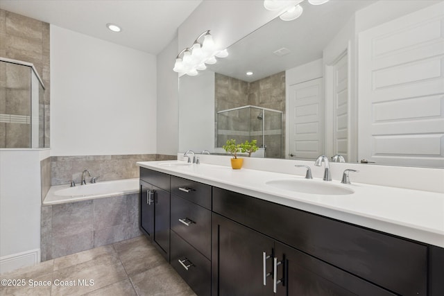 bathroom featuring a shower stall, a garden tub, a sink, and tile patterned flooring