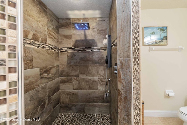 1 Eighth Ave Unit 1204, Indialantic, FL 32903 - full bath with a tile shower, baseboards, tile patterned flooring, and toilet