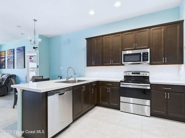 2515 SE Marquez Ave SE, Palm Bay, FL 32909 - kitchen with dark brown cabinets, a sink, light countertops, stainless steel appliances, and open floor plan