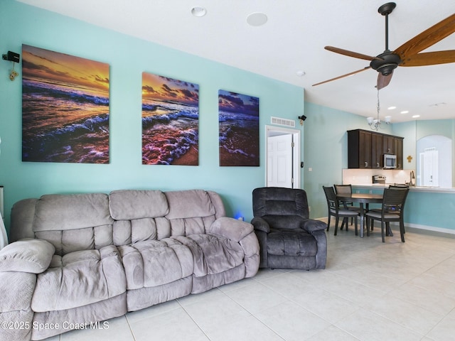 2515 SE Marquez Ave SE, Palm Bay, FL 32909 - living room featuring visible vents, baseboards, arched walkways, a ceiling fan, and light tile patterned flooring
