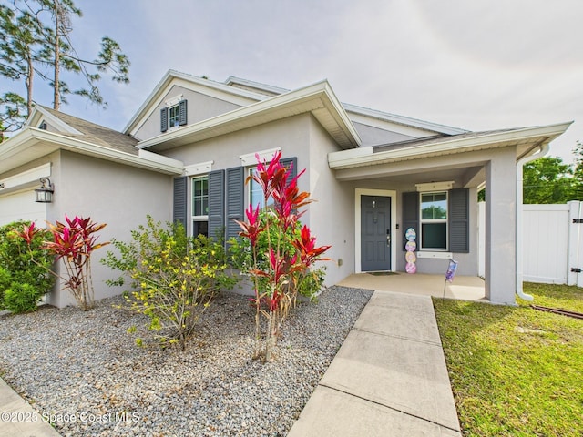 2515 SE Marquez Ave SE, Palm Bay, FL 32909 - view of front of property with an attached garage, covered porch, stucco siding, and fence