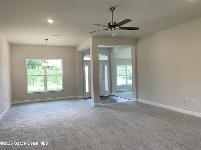 2205 Sans Souci Ave SE, Palm Bay, FL 32909 - carpeted empty room featuring healthy amount of natural light, ceiling fan, a chandelier, and a textured ceiling