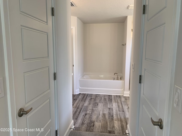 2205 Sans Souci Ave SE, Palm Bay, FL 32909 - bathroom featuring a tub to relax in, wood finished floors, and a textured ceiling