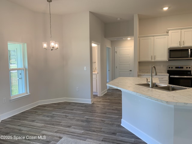 2205 Sans Souci Ave SE, Palm Bay, FL 32909 - kitchen with appliances with stainless steel finishes, white cabinetry, a chandelier, dark wood-style flooring, and pendant lighting