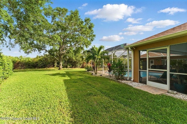 view of yard featuring an outdoor pool and glass enclosure