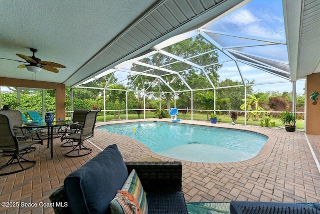 pool with a lanai, outdoor dining space, a patio area, and a ceiling fan