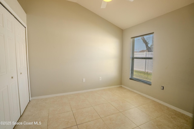 3780 Starlight Ave, Merritt Island, FL 32953 - unfurnished bedroom featuring a closet, light tile patterned flooring, baseboards, and vaulted ceiling