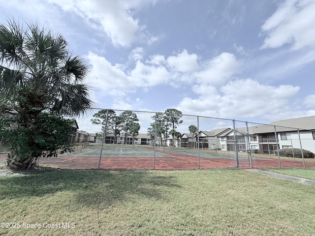 view of sport court featuring a lawn and fence