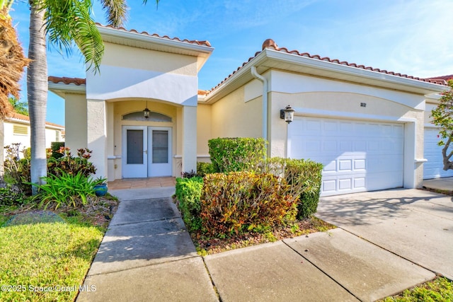 8657 Villanova Dr Unit 901, Cape Canaveral, FL 32920 - view of front of home with a garage, driveway, french doors, and a tiled roof