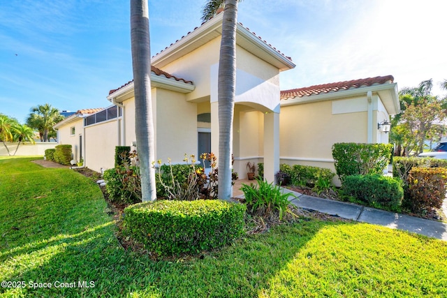 8657 Villanova Dr Unit 901, Cape Canaveral, FL 32920 - view of property exterior with a yard, stucco siding, and a tiled roof