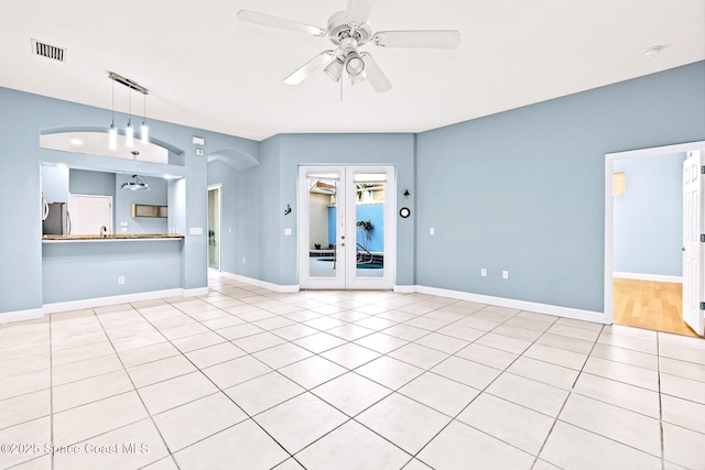 8657 Villanova Dr Unit 901, Cape Canaveral, FL 32920 - unfurnished living room featuring arched walkways, visible vents, baseboards, and a ceiling fan