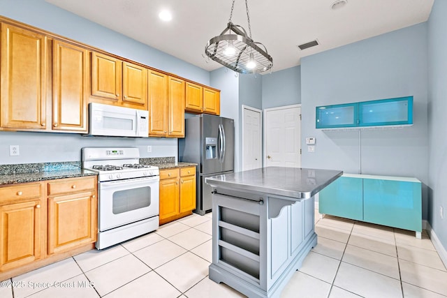 8657 Villanova Dr Unit 901, Cape Canaveral, FL 32920 - kitchen featuring dark stone countertops, light tile patterned flooring, white appliances, and visible vents
