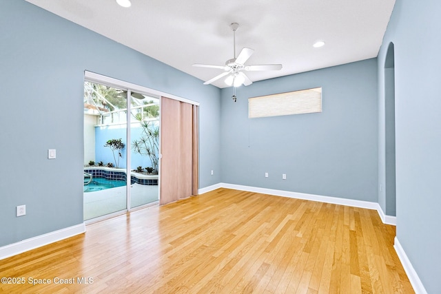 8657 Villanova Dr Unit 901, Cape Canaveral, FL 32920 - empty room featuring arched walkways, light wood-type flooring, baseboards, and ceiling fan