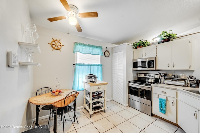 999 Jupiter Blvd NW, Palm Bay, FL 32907 - kitchen with light tile patterned floors, a ceiling fan, white cabinets, appliances with stainless steel finishes, and light countertops