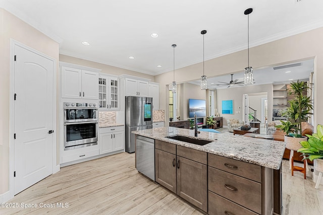 kitchen featuring crown molding, a sink, a ceiling fan, and stainless steel appliances
