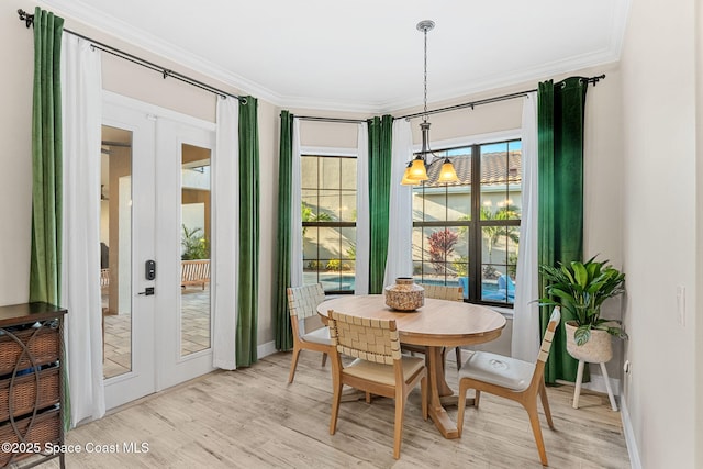 dining area featuring crown molding, french doors, and light wood finished floors