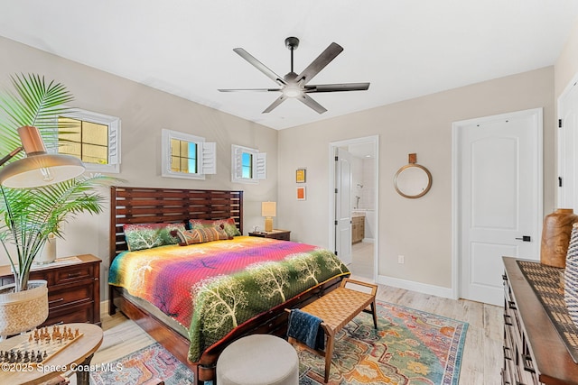 bedroom featuring light wood-style flooring, ensuite bathroom, baseboards, and a ceiling fan