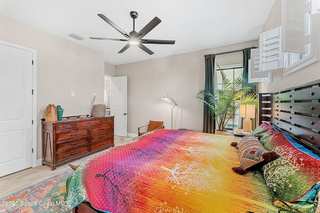 bedroom with visible vents, baseboards, light wood-type flooring, and a ceiling fan