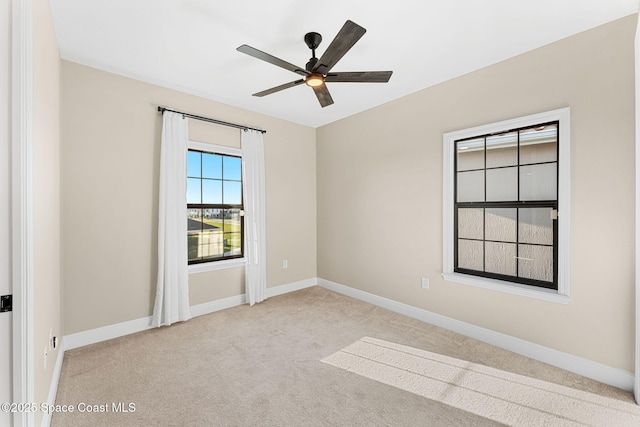 empty room with baseboards, ceiling fan, and carpet