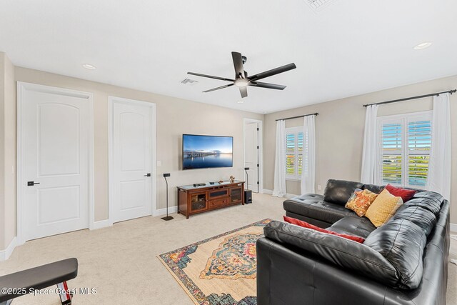carpeted living room with plenty of natural light, visible vents, baseboards, and ceiling fan