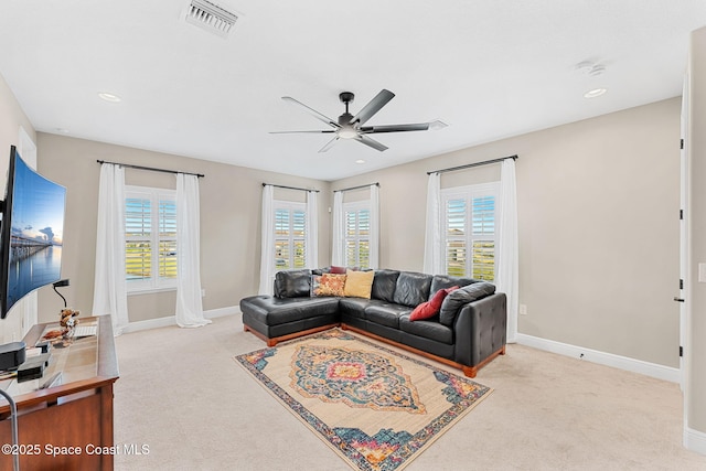 carpeted living room featuring visible vents, baseboards, a ceiling fan, and a healthy amount of sunlight