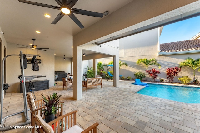 view of pool featuring a patio area, outdoor lounge area, a ceiling fan, and a fenced in pool
