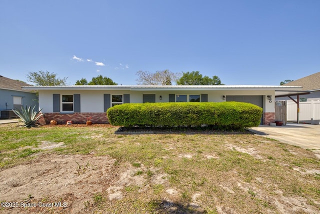 ranch-style house featuring fence, an attached garage, brick siding, central AC unit, and driveway