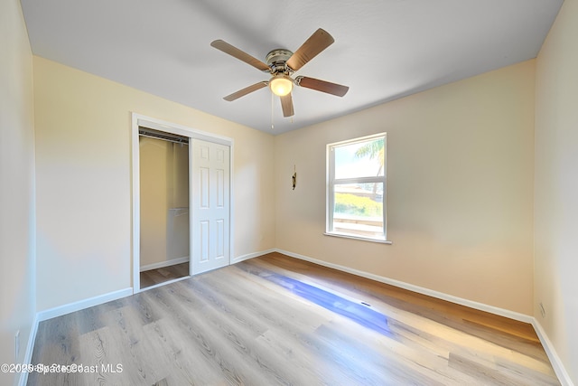 unfurnished bedroom featuring baseboards, a closet, and wood finished floors