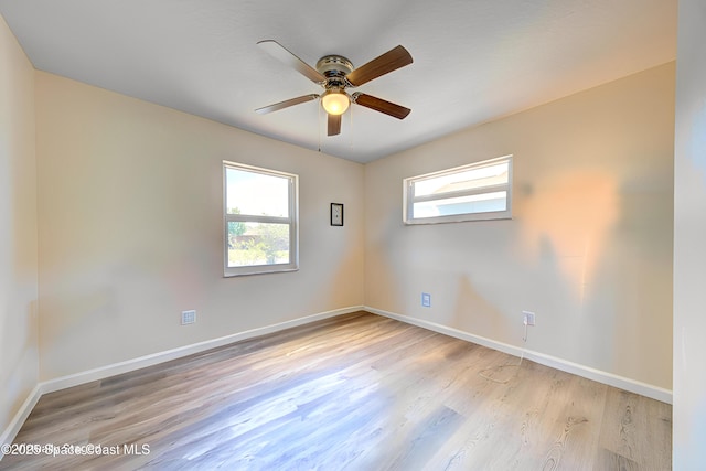 empty room with baseboards, ceiling fan, and wood finished floors