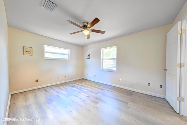 unfurnished room with baseboards, visible vents, a ceiling fan, and a wealth of natural light