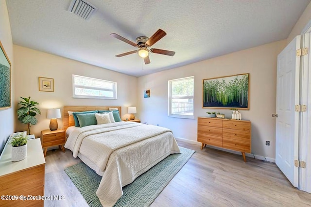 bedroom featuring multiple windows, light wood finished floors, and visible vents