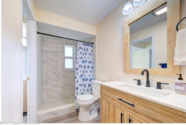 bathroom featuring toilet, a tile shower, and vanity