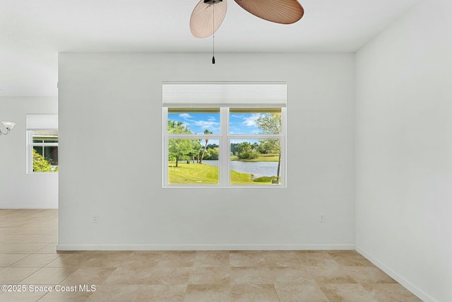 unfurnished room with a water view, plenty of natural light, baseboards, and ceiling fan