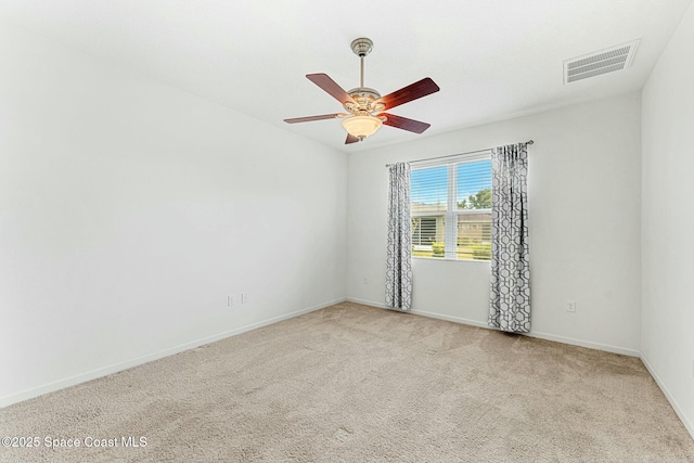 carpeted empty room with visible vents, ceiling fan, and baseboards