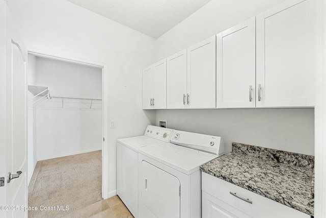 laundry room featuring washer and dryer, light colored carpet, baseboards, and cabinet space
