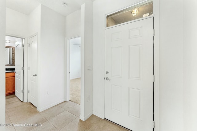 entrance foyer with light tile patterned floors and baseboards