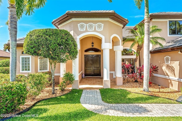 entrance to property featuring a tiled roof and stucco siding