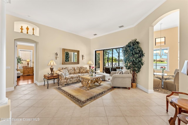 living room featuring a high ceiling, light tile patterned floors, baseboards, and ornamental molding