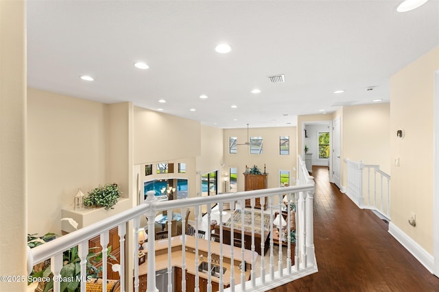 hall with baseboards, recessed lighting, an upstairs landing, visible vents, and wood finished floors