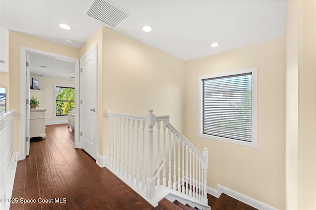 corridor with recessed lighting, an upstairs landing, visible vents, and dark wood-style flooring