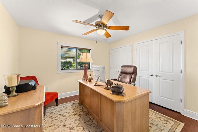 office space featuring baseboards, wood finished floors, and ceiling fan