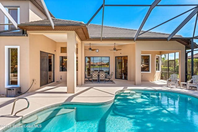 back of house with a patio area, a lanai, ceiling fan, and stucco siding
